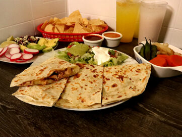 quesadilla with meat with a side of guacamole