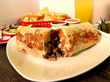 Burrito plate with totopos and hot sauces